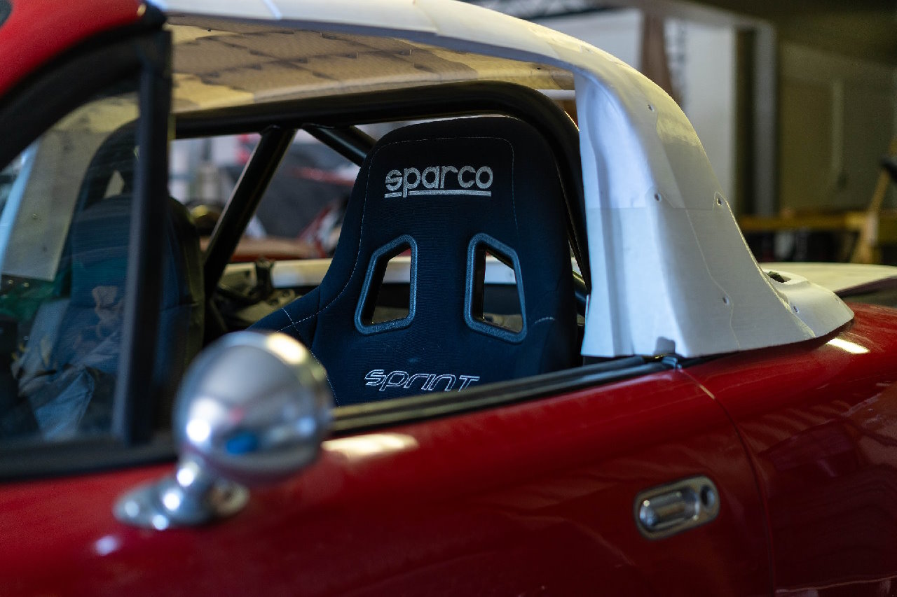 Photo d'une MX5 NA avec un zoom sur le hard-top en impression 3D et un siège baquet Sparco